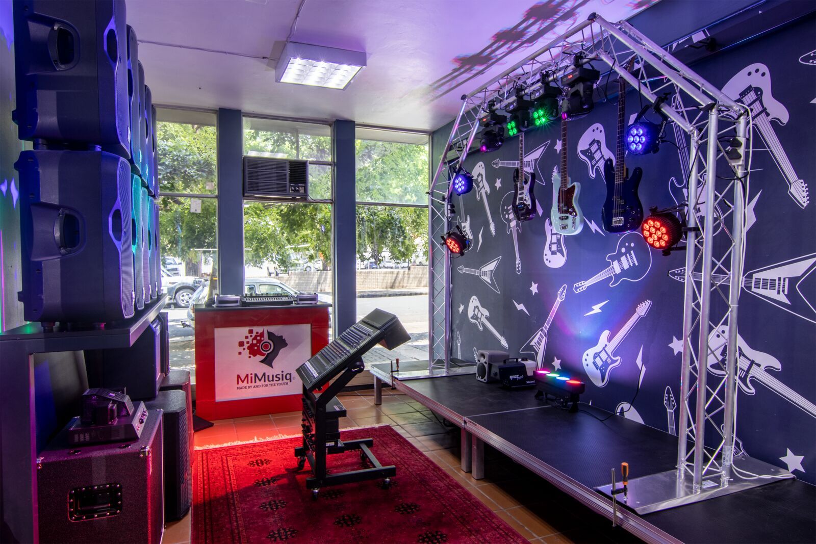 PASMA's live production room: stage, lighting truss and PA rig under colour washes