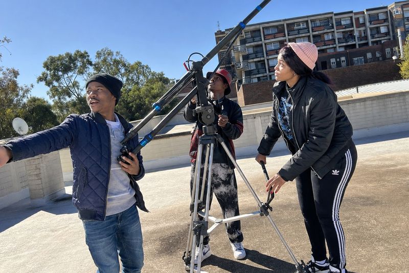 Film and TV students framing a shot with the camera crane on location
