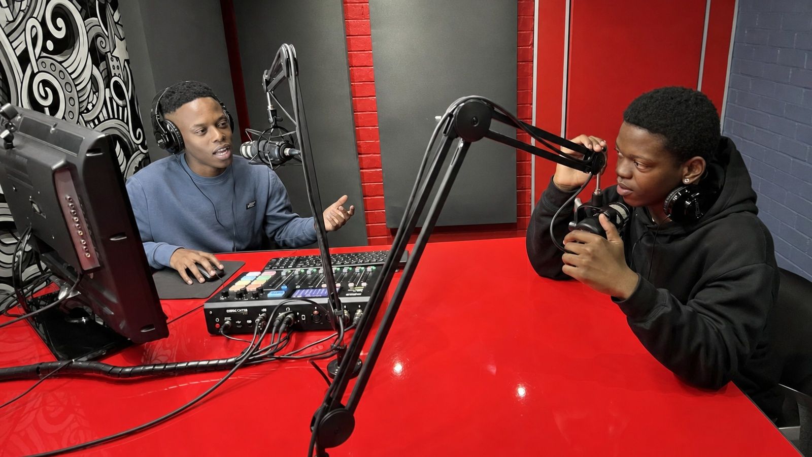 Students broadcasting live from the red PASMA radio studio
