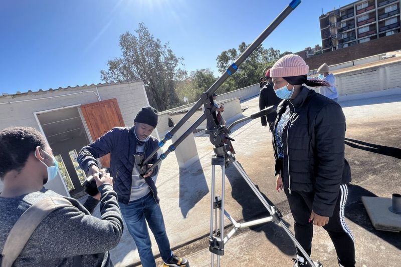Film and TV students operating a camera crane during an on-location practical