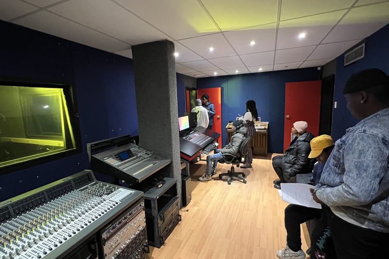 Students gathered around the mixing console during a Studio A console practical